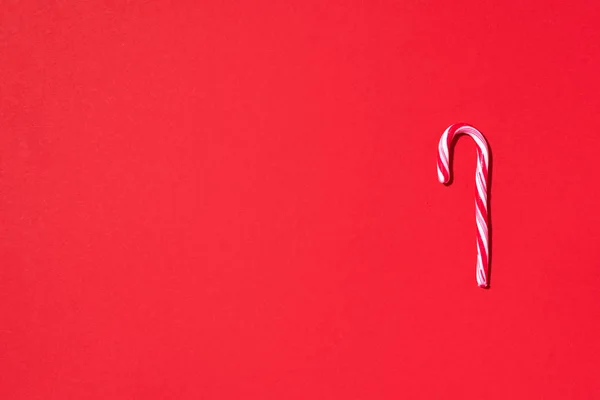 Kırmızı arka planda fotokopi alanı olan Noel şekeri kamışı. Üst Manzara. Noel ve Yeni Yıl 'da tebrik kartı. Minimum festival konsepti — Stok fotoğraf