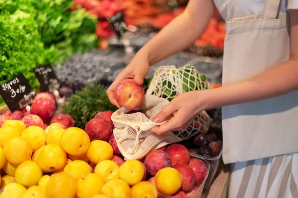 Cero residuos, concepto libre de plástico. Estilo de vida sostenible. La mujer elige frutas y verduras en el mercado de agricultores. Bolsas ecológicas de algodón y malla reutilizables para ir de compras . — Foto de Stock