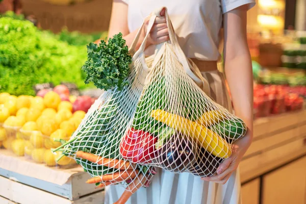 Zero waste concept with copy space. Woman holding cotton shopper and reusable mesh shopping bags with vegetables, products. Eco friendly mesh shopper. Zero waste, plastic free concept. — Stock Photo, Image