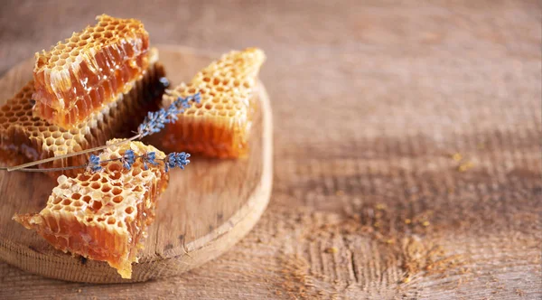 Pezzi di favi freschi, fiori di lavanda asciutti su sfondo di legno. Concetto di raccolta autunnale — Foto Stock