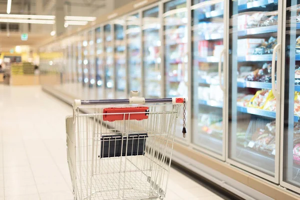 Empty red shopping cart in supermarket interior. Copy space. Sustainable lifestyle. Sale, discount concept — Stock Photo, Image