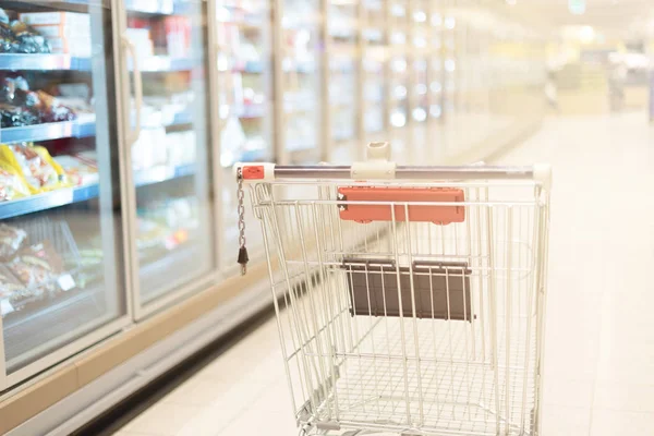 Empty red shopping cart in supermarket interior. Copy space. Sustainable lifestyle. Sale, discount concept — Stock Photo, Image