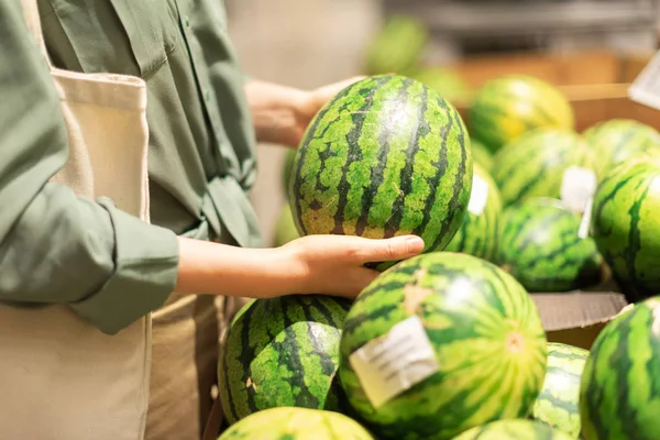 Žena si vybírá meloun na trhu. Nulový odpad, bezplastový koncept. Udržitelný životní styl. Zdravé potraviny, bio, vegetariánská strava koncepce — Stock fotografie