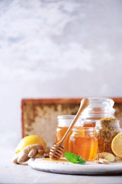 Sağlıklı sıcak içecek için gerekli malzemeler. Limon, zencefil, nane, bal, elma ve baharatlar gri arka planda. Uzayı kopyala Alternatif tıp konsepti. Temiz yemek, detoks.