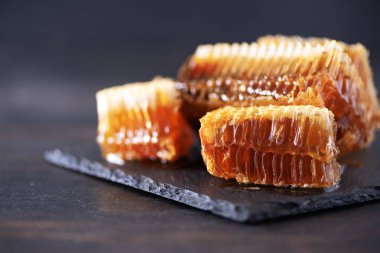 Taze bal peteği parçaları, siyah arka planda kuru lavanta çiçekleri. Sonbahar hasat konsepti