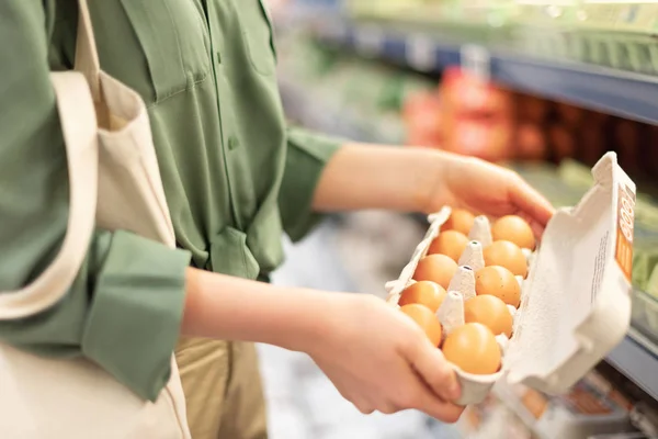 Girl at supermarket holding cotton shopper bag and buying eggs in craft package without plastic bags. Zero waste, plastic free concept. Sustainable lifestyle. Banner. — Stock Photo, Image