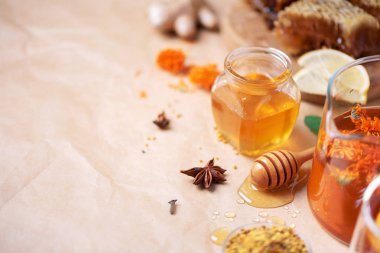 Sonbahar hasat konsepti. Bal ve arı ürünleri seti, elma, limon, arkaplanda baharatlar. Alternatif tıpla bağışıklık sistemi desteği