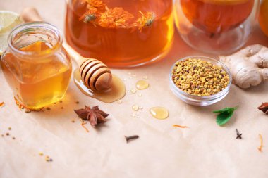 Alternatif tıp konsepti. Doğal sıcak içecekle savaşan grip malzemeleri. Uzayı kopyala Limon, zencefil, nane, bal, elma ve baharatlar kağıt üzerinde