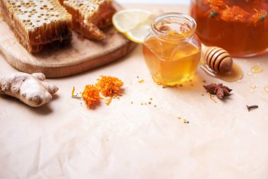 Alternatif tıp konsepti. Doğal sıcak içecekle savaşan grip malzemeleri. Uzayı kopyala Limon, zencefil, nane, bal, elma ve baharatlar kağıt üzerinde