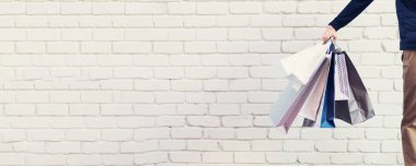 Bir sürü alışveriş torbası olan bir adam. Uzayı kopyala İndirim, indirim, Kara Cuma konsepti. Alışveriş merkezi ve priz. Pankart