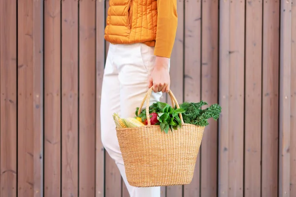 Zero waste concept with copy space. Woman holding straw basket with vegetables, products. Eco friendly shopper. Zero waste, plastic free concept.