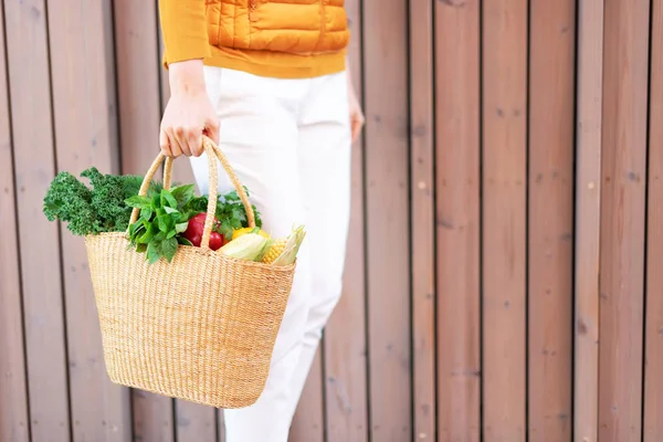 Concepto de cero residuos con espacio de copia. Mujer sosteniendo cesta de paja con verduras, productos. Comprador ecológico. Cero residuos, concepto libre de plástico . — Foto de Stock