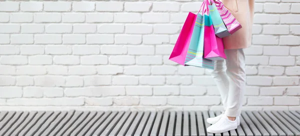 Chica con estilo en ropa blanca sosteniendo bolsas de compras de color rosa. Venta, descuento, concepto de viernes negro. Centro comercial y outlet —  Fotos de Stock