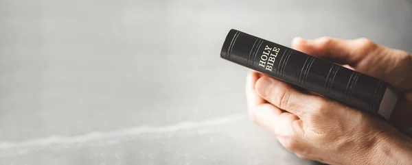 灰色の背景に聖書を持つ手 福音を若者と分かち合う コピースペース キリスト教の概念 — ストック写真