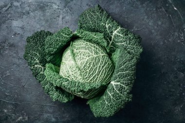 Çiğ yeşil lahana dokusu. Karanlık arka planda organik savoy lahanası. Üst Manzara. Uzayı kopyala Vejetaryen ve vejetaryen diyet kavramı.