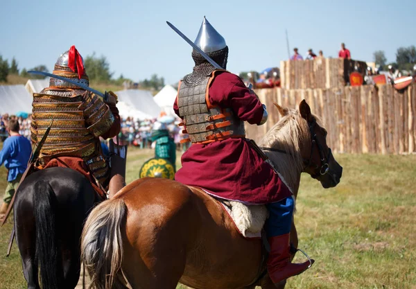 Ricostruzione. Paese. Cavaliere medievale con lancia a cavallo dalla fantasia. Soldati equestri in costumi storici è nel campo militare — Foto Stock