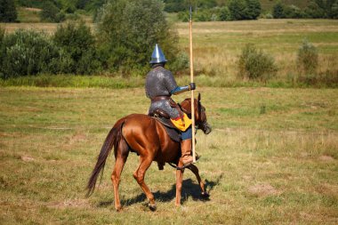 Ortaçağ zırhlı şövalye whith lance atın üstünde. Atlı asker tarihsel kostüm. Reenactor alanındadır