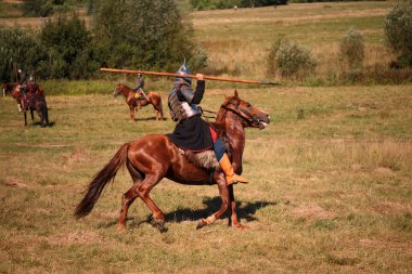 Yeniden yapılanma. Lance fantezi gelen atlı ile Ortaçağ zırhlı atı. Atlı asker tarihsel kostüm. Reenactor alanındadır