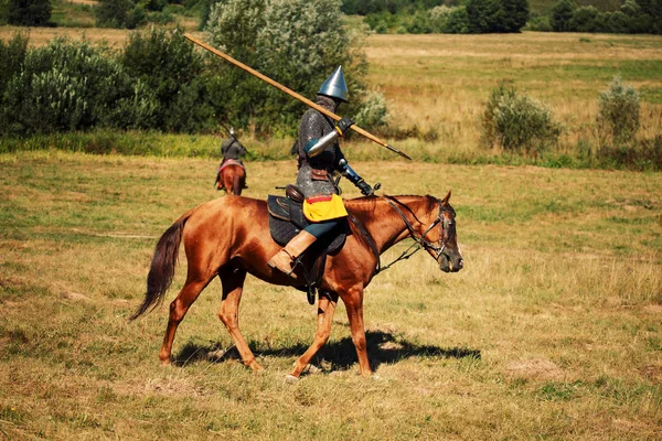 Medieval armored equestrian soldiers with lances on horses — Stock Photo, Image