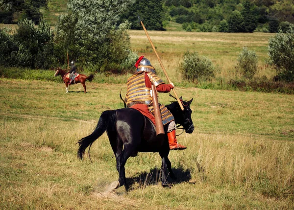 Dois cavaleiros lutam. Soldados equestres blindados medievais com lanças. Cavaleiros em cavalos estão no verão — Fotografia de Stock