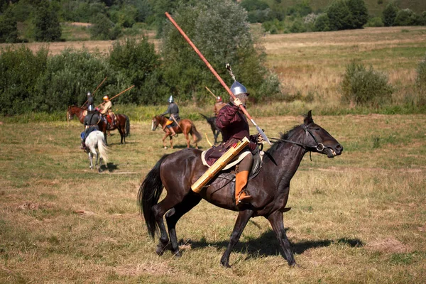 Реконструкция. Средневековый бронированный рыцарь с копьем на коне от фантазии. Конный солдат в историческом костюме. Всадник в поле — стоковое фото