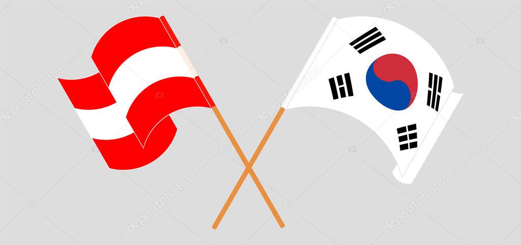 Crossed and waving flags of Austria and South Korea
