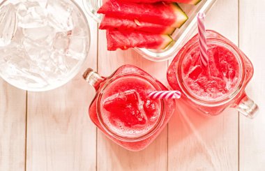 yaz içecekler kavramı. karpuz dilimleri ve Beyaz ahşap zemin üzerinde mason kavanoza smoothies görünümü top.