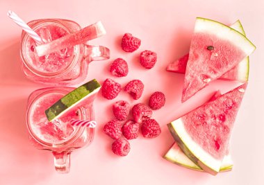 yaz içecekler kavramı. karpuz dilimleri ve pembe bir arka plan üzerinde mason kavanoza smoothies görünümü top.