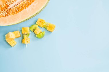 yaz meyve kavramı. kivi ve ananas kanepeler mavi yarısıyla düz arka plan kavun üstten görünüm yatıyordu