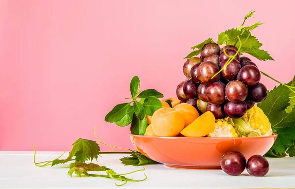 Montón Albaricoques Frescos Uvas Callos Plato Color Naranja Con Hojas — Foto de Stock