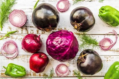 çiğ mor sebzeler patlıcan, lahana, soğan, elma üstten görünüm beyaz rustik arka planda