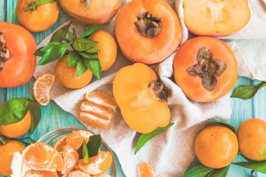 hurma ve mandalina düzen düz üstten görünüm mavi ahşap masa üzerinde yatıyordu