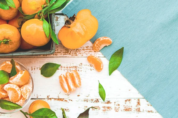Caquis y mandarinas sobre mesa de madera blanca vista superior — Foto de Stock