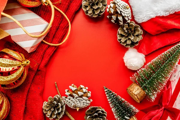 빨간색 배경에 산타 모자와 전나무 나무, 소나무 콘, 선물, 크리스마스 양말 — 스톡 사진