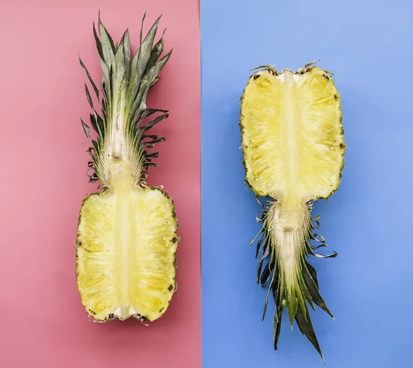 Creative layout made of pineapple on pink and blue background. Tropical flat lay. Food concept.