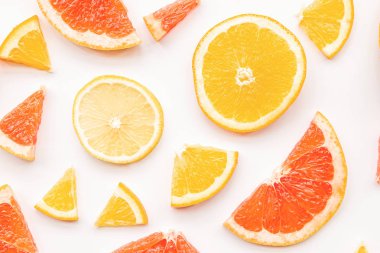 Taze yaz narenciye greyfurt, portakal ve limon dilimleri desen beyaz arka plan düz üst görünümü yatıyordu
