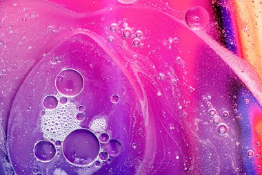 Su üzerinde yağ kabarcıkları ile yapılan pembe ve mor soyut desen