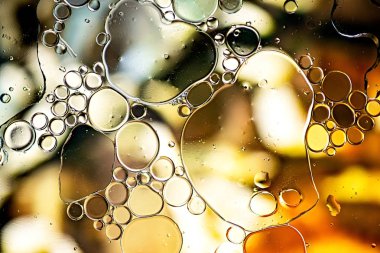 Su üzerinde yağ kabarcıkları ile yapılan siyah ve altın soyut desen