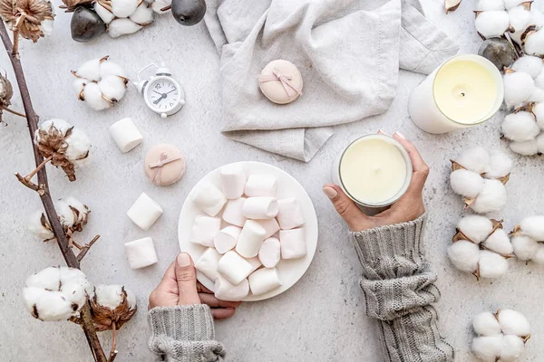 Espacio de trabajo femenino en tonos pastel. Malvaviscos, algodón, velas vista superior sobre fondo de mármol blanco — Foto de Stock