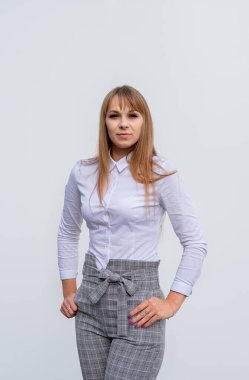 Gri arka planda kendine güvenen beyaz bir iş kadınının ön manzara portresi