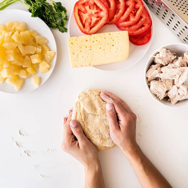Жіночі руки готують тісто для піци на білому столі — стокове фото