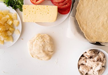 Beyaz masa üstünde pizza hamuru pişirmek.