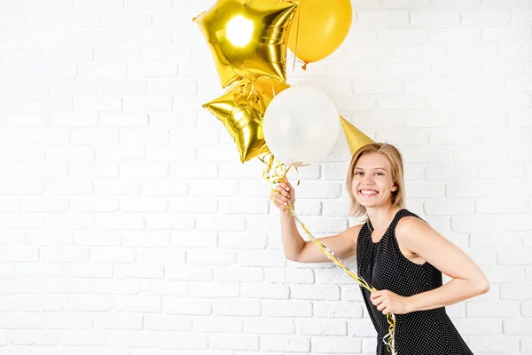 Verjaardagsfeestje Jonge Blonde Glimlachende Vrouw Draagt Verjaardagshoed Met Gouden Ballonnen — Stockfoto