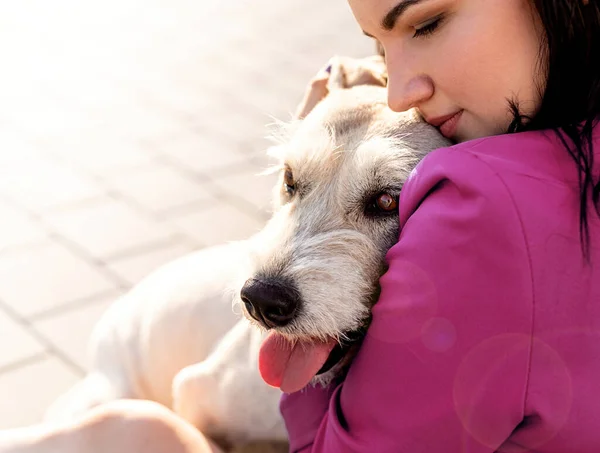 Joven atractiva mujer abrazando a su perro en el parque — Foto de Stock
