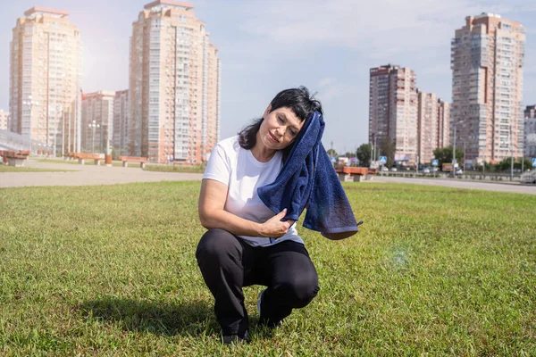 Sport and fitness. Senior sport. Active seniors. senior woman wiping out sweat after hard workout outdoors in the park