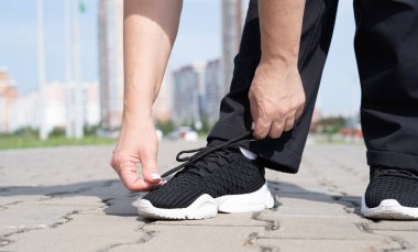 Spor ve spor. Son sınıf sporu. Aktif son sınıflar. Kadın ayakkabı bağcıklarını açık havada takıyor.