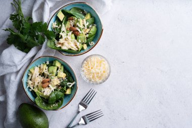 Taze yaz avokadosu, ıspanak salatası kaseleri ve düz kopya alanı manzarası.