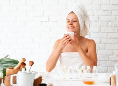 Spa and beauty concept. Happy young woman wearing white bathrobes towels on head doing spa procedures in spa beauty salon clipart
