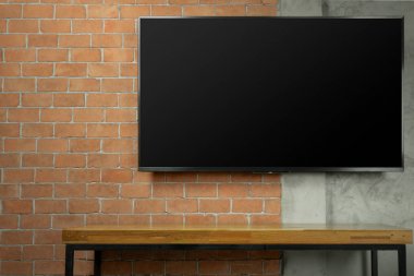 boş ekran Led Tv boş medya ahşap masa ile kırmızı tuğla duvar