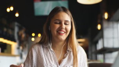 Genç casual işkadını kol Resepsiyon geri kalanı üzerinde dizüstü bilgisayar ve kulaklık ile müzik dinleme ile poz ve çalışmaları hakkında düşünmek
